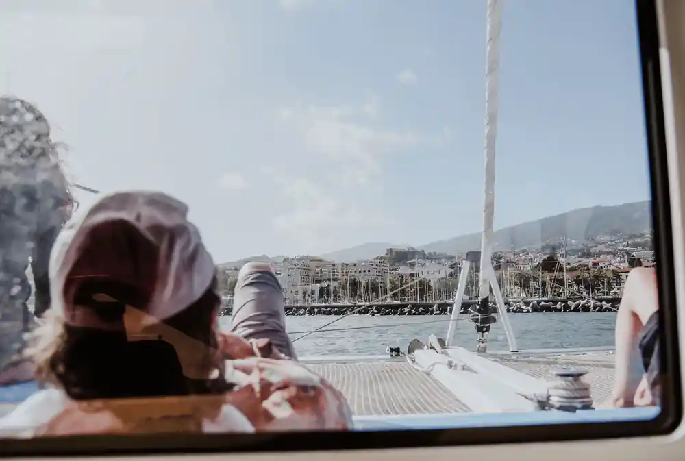 A guest resting on the foredeck with Funchal behind