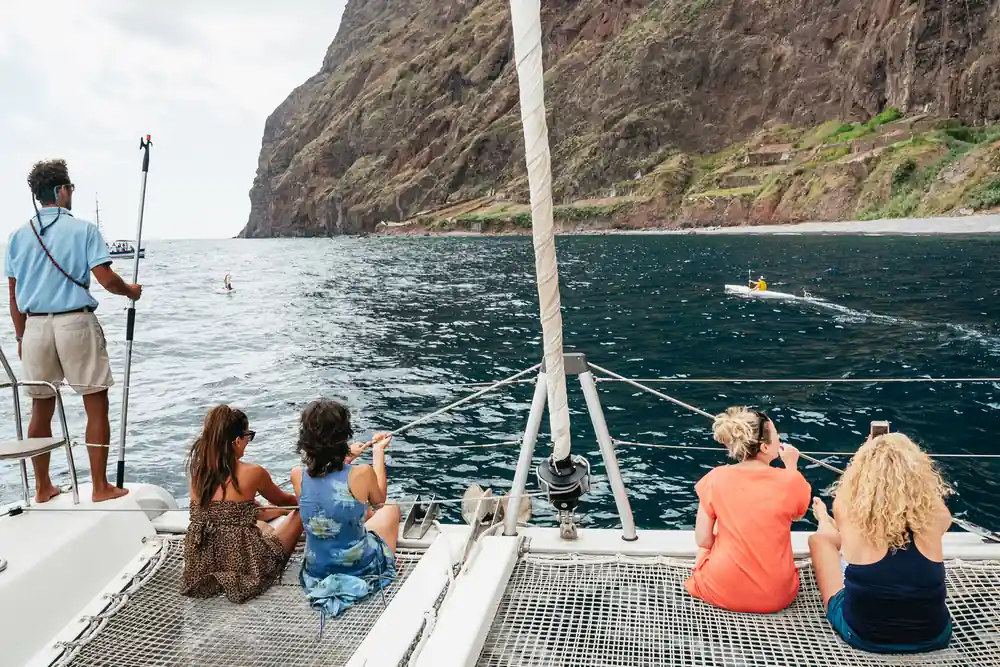 Guests sitting on the trampoline nets with the cliff behind
